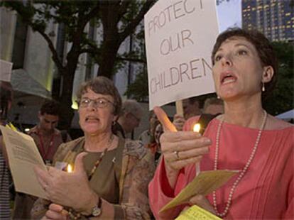 Dos mujeres durante una vigilia a las afueras del edificio en el que se reúnen los obispos católicos en Dallas.