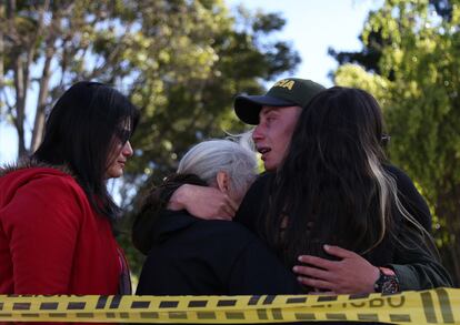 Un policía abraza a sus familiares después de la explosión en la academia de policía General Santander en Bogotá, el 17 de enero de 2019.