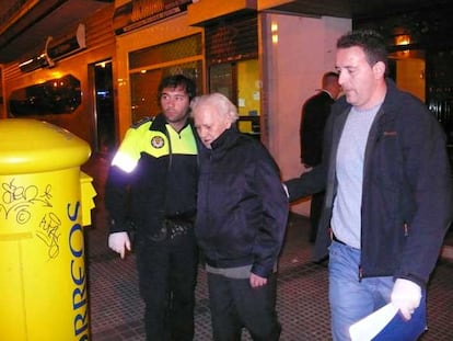 Carlos Domínguez (en el centro) sale de su casa detenido por la policía.