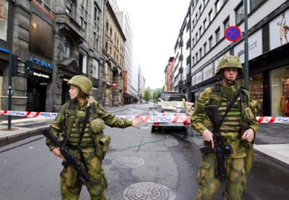 Dos soldados vigilan la zona acordonada tras la explosión de ayer en Oslo.