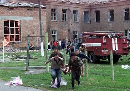 Un grupo de voluntarios saca a un herido de la escuela.