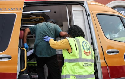 Una trabajadora del Samur Protección Civil ayuda a un hombre a subir a una ambulancia para su traslado a un centro hospitalario, en agosto de 2021.