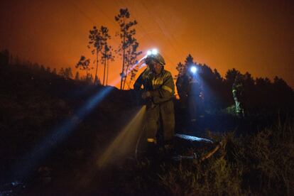 Varios brigadistas realizan trabajos extinción en el incendio forestal declarado en la localidad orensana de Entrimo, uno de los muchos incendios forestales sin control que han cercado casas, provocado desalojos y afectado a zonas de alto valor ecológico, el 6 de septiembre.