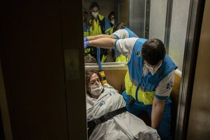 El técnico de emergencias Francisco Miguel Pérez baja a María Paz, 29 años, en el ascensor para trasladarla al Hospital 12 de Octubre.