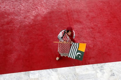 Una mujer camina con una bandera de Cachemira para expresar solidaridad con la ciudad, durante una ceremonia que celebra el 72 aniversario del Día de la Independencia de Pakistán en el Mausoleo de Muhammad Ali Jinnah en Karachi (Pakistán).
