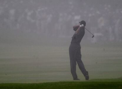 Tiger Woods golpea la bola bajo la niebla en el hoyo 18, en la primera jornada. El golfista acab levantando su primera corona en este torneo.