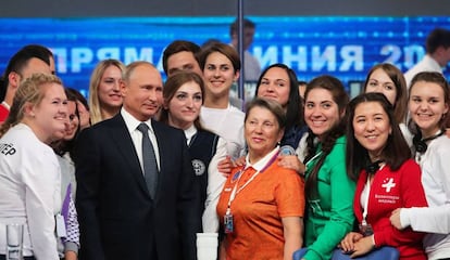 El presidente ruso, Vladímir Putin, posa con un grupo de voluntarios tras su programa nacional en directo.