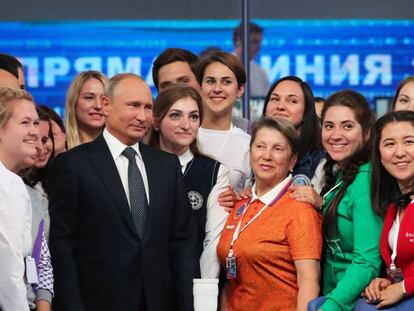 El presidente ruso, Vladímir Putin, posa con un grupo de voluntarios tras su programa nacional en directo.