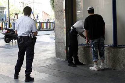 Dos policías identifican a un hombre en los soportales de la plaza de Soledad Torres Acosta.