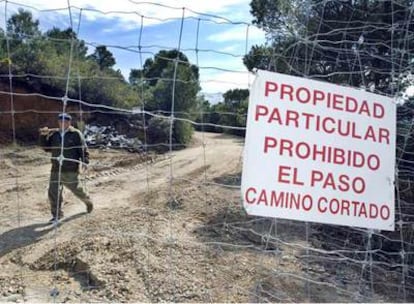 Un trabajador de Antonio Quesada, presunto asesino de Fernando Jurado, enseña la valla que divide los terrenos de ambos, motivo de disputa.