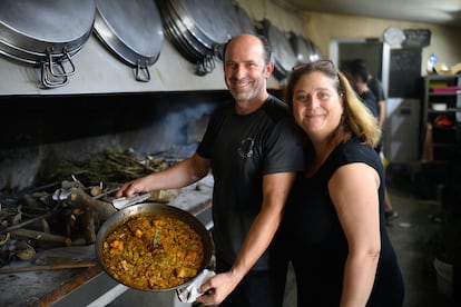 José Sanchis y Carmina Crespo muestran una paella a leña recién hecha en el restaurante L'Alter.