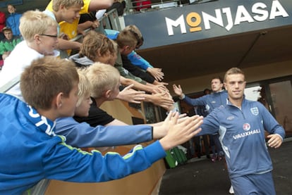 El jugador de la selección inglesa de fútbol sub-21, Jordan Henderson, saluda a un grupo de jóvenes aficionados a su llegada al entrenamiento de Fredericia (Dinamarca).