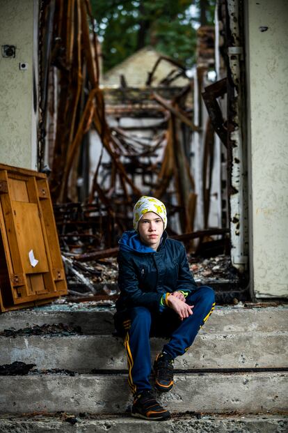Misha posa en uno de los muchos edificios de Bucha que permanecen calcinados tras los combates entre tropas ucranias y rusas el pasado mes de marzo. 
