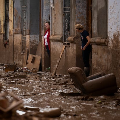 Women stand at the entrance of their houses affected by flooding in Masanasa, Valencia, Spain, Wednesday, Nov. 6, 2024. (AP Photo/Emilio Morenatti)