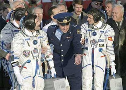Un oficial ruso invita a Duque (derecha) y a Alexander Kareli a entrar en la nave Soyuz. El tercer astronauta, Michael Foale, aparece tapado a la izquierda.