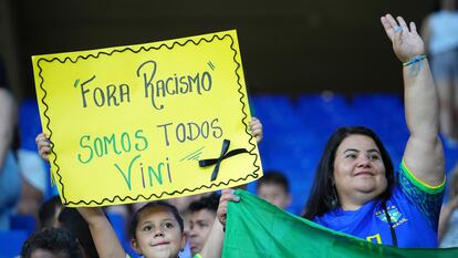 Un seguidor de Brasil sostiene un cartel que dice "Fuera el racismo" en apoyo a Vinicius Junior el 17 de junio de 2023 en Barcelona.