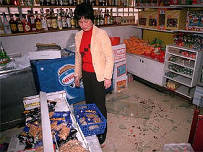 La viuda del comerciante chino observa la sangre y los destrozos registrados en el local durante el atraco.