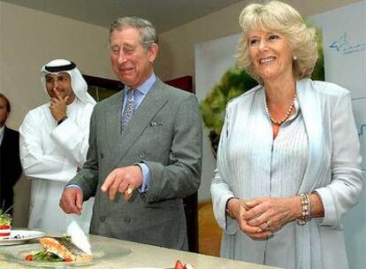 El príncipe de Gales y la duquesa de Cornualles, ante un filete de salmón durante su visita al centro contra la diabetes de Abu Dhabi.