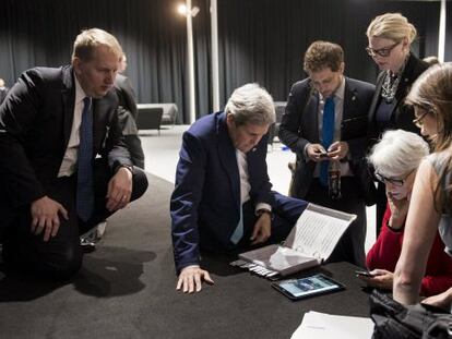 Kerry mira en una tableta el discurso de Obama en Washington sobre el pacto