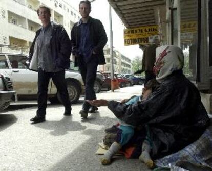 Una indigente gitana con su hijo en los brazos pide dinero a unos viandantes, ayer en Pogdorica.