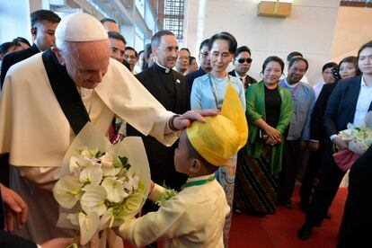 El papa Francisco, junto a líder de Myanmar, Aung Suu Kyi, saluda a un niño que le entrega unas flores en Naypyitaw, el 28 de noviembre.