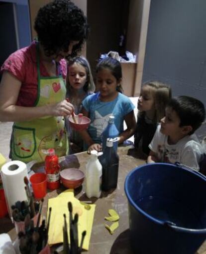 Una monitoria explica cómo mezclar pintura a los niños en uno de los talleres de la Fundación Amberes.