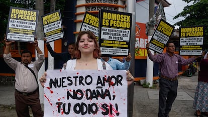 Miembros religiosos sostienen pancartas durante desfile del orgullo LGBTQIA+ en San Salvador, el 24 de junio de 2023.