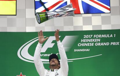 Lewis Hamilton lanza su trofeo en el podio.