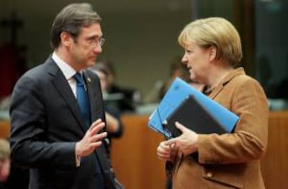 La canciller alemana, Angela Merkel, habla con el primer ministro portugués, Pedro Passos Coelho, ayer durante la cumbre extraordinaria para negociar el presupuesto plurianual para 2014-2020, en Bruselas (Bélgica).