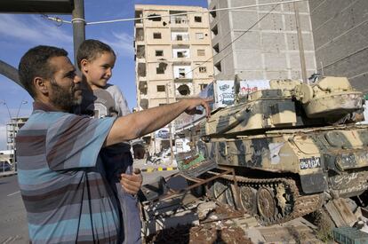 El brigadista Jalid Shabha, de 41 años, contemplaba ante el museo callejero de la revolución los tanques despanzurrados de Muamar el Gadafi, los trofeos de guerra que la gente de Misrata lograron arrebatar en 2011. Su hijo, Abdur, que nació el mismo 20 de octubre a las once de la noche en que la gente de Misrata capturaba y mataba a Muamar el Gadafi, sonríe entre los brazos de su padre, el 23 de febrero de 2016.