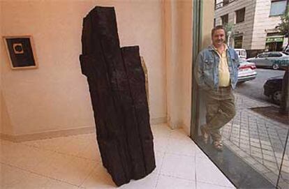 Koldobika Jauregi posa junto a su escultura en madera 'Asedio' a las puertas de la Galería Arteko, ayer en San Sebastián.