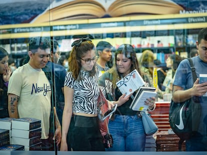 Asistentes a la feria Internacional del Libro de Guadalajara revisan algunos de los títulos a la venta, el 2 de diciembre de 2022.