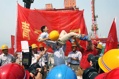 Trabajadores chinos celebran el fin de obra del principal muro de la presa de las Tres Gargantas en Yichang.
Soldados británicos en Irak. 
/ REUTERS