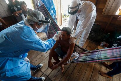 Trabajadores sanitarios miden la temperatura de un hombre en una comunidad ribereña del río Murutipucu en Igarape-Miri (Brasil). El país es el tercero más afectado por la pandemia, registra 4,45 millones de contagiados y 134.935 muertos, tras sumar en el último día más de 36.000 positivos.