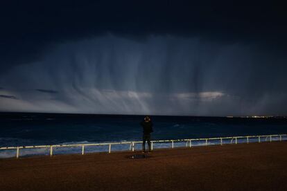 Un hombre mira una tormenta sobre el Mediterráneo en la ciudad francesa de Niza.