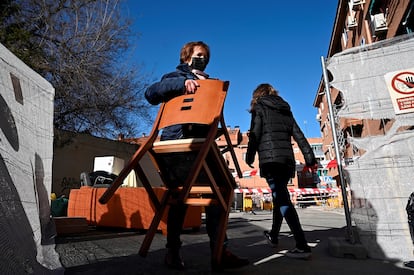 Una vecina acarrea una silla mientras vacía su casa. 