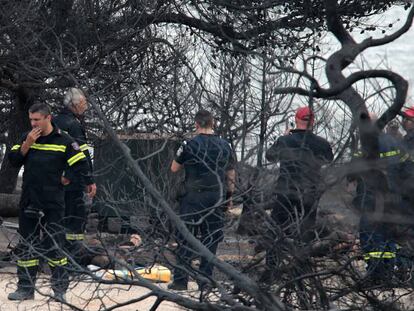 Bombeiros junto aos cadáveres carbonizados em Mati.