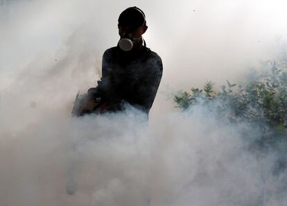 Un soldado rocía sustancias químicas para matar a los mosquitos durante una campaña contra la fiebre del dengue en una comunidad residencial de Bangkok (Tailandia).