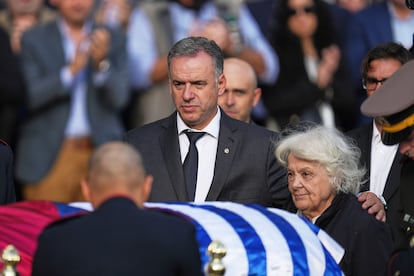 El presidente Yamandu Orsi, izquierda, junto a Lucia Topolansky, viuda de José Mujica, caminan frente al ataúd en el Palacio Presidencial de Montevideo.