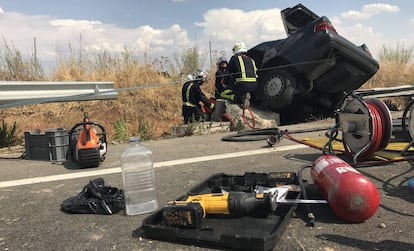 Los bomberos rescatan el cuerpo del conductor fallecido.