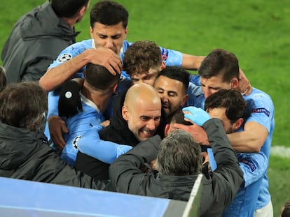 Los jugadores del City abrazan a Guardiola tras un gol