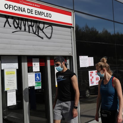 Dos jóvenes pasan ante una oficina de empleo en Madrid.