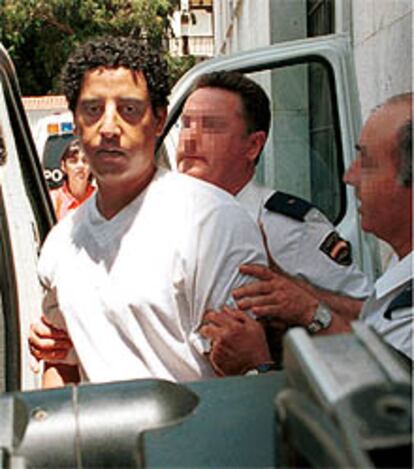 Cherki Hadij es conducido por miembros de la Policía Nacional al coche celular tras la vista.
