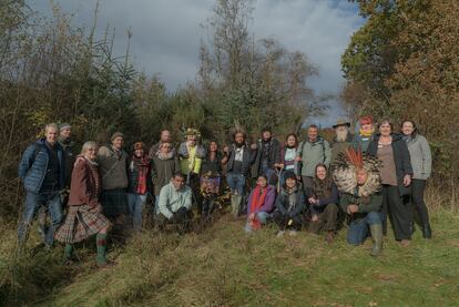 Miembros de la comunidad Kilfinan y la delegación de la Alianza Global de Comunidades Territoriales (GATC) posan junto al roble que ha plantado juntos.