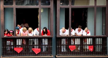 Varias personas observan el quinto encierro de Sanfermines desde un balcón, el 11 de julio de 2018. 