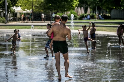 Un padre, junto a su hija, se bañan en los 'chorros' de Madrid Río.