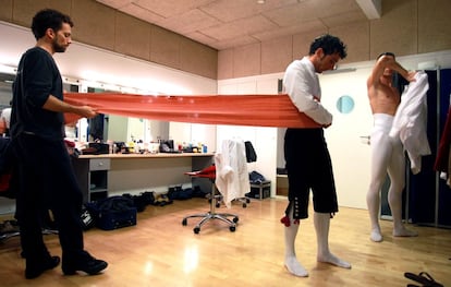 Un bailarín es ayudado a vestirse antes del espectáculo.