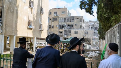 Varias personas contemplan una sinagoga dañada en Israel por ataques de Irán.