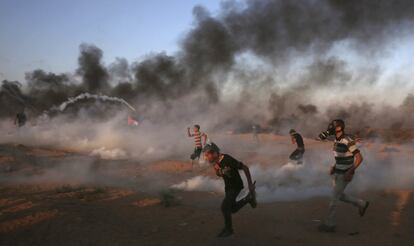 Los manifestantes corren para protegerse del gas lacrimógno lanzado por las tropas israelíes, el 12 de octubre de 2018, en la Franja de Gaza. 