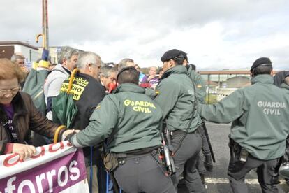 Guardias civiles forcejean con manifestantes para que no traspasen las vallas ante el congreso del PP de Pontevedra, en Silleda.